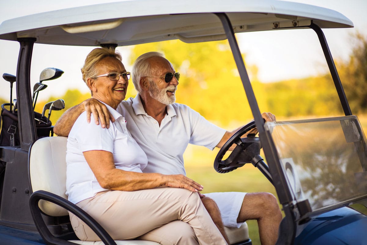 elderly couple golfing